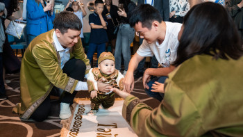 Фотография к новости: Танымал шахматшы Дин Лижэнь бүлдіршіннің тұсауын кесті