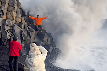 Фотоға түсіп тұрған туристерді жағалаудағы дауылды толқын шайып кетті